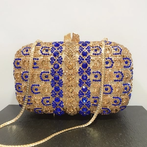 Détail des strass géométriques étincelants et du cadre en métal doré sur la pochette de soirée
