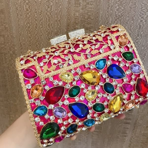 Detail of luxury rhinestone evening clutch with colorful gems and gold metal filigree