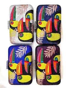 Detail view of four square crystal evening clutches with tropical toucan rhinestone designs