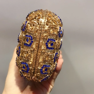 Détail d'une pochette de soirée sphérique sertie de strass dorés et bleus à la main