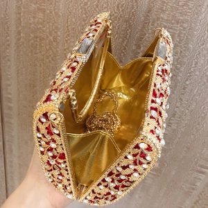 Detail of red clutch bag interior with gold chain strap and crystal embellishments