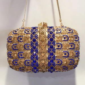 Détail d'une pochette de soirée ornée de strass bleus et ambrés avec motif en nid d'abeille