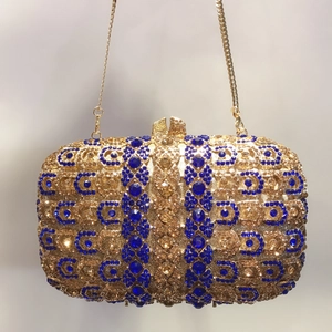 Détail d'une pochette de luxe sertie de cristaux bleus et d'une chaîne dorée