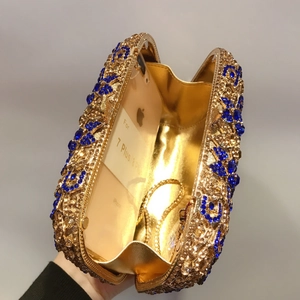 Détail de l'intérieur d'une pochette de luxe montrant la doublure dorée et la capacité