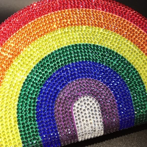 Macro shot of vibrant rainbow rhinestones set on a semicircular evening clutch bag