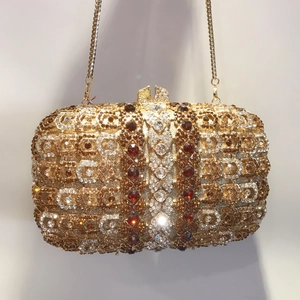 Gros plan d'une pochette de soirée dorée avec motif luxueux en strass et chaîne fine