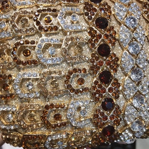Détail macro d'une pochette de luxe avec cristaux hexagonaux et pierres ambre florales