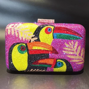 Macro shot of colorful toucan rhinestone evening bag with intricate palm leaf detail