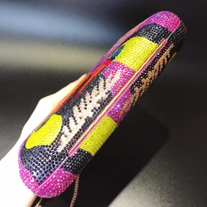 Close-up of luxury evening clutch with multi-colored rhinestone pattern and metal chain