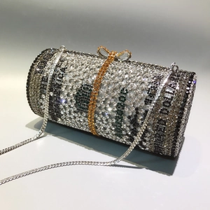 Detail of crystal cylindrical evening clutch featuring 100 dollar bill pattern and bow