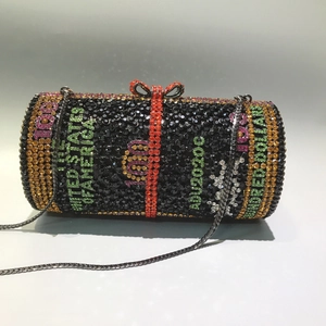 Detail of crystal cylindrical evening bag with dollar bill design and bow clasp