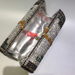 Detail of crystal dollar bill clutch open with silver interior and metal chain strap