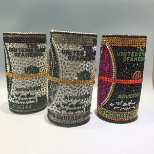 Detailed view of cylindrical money roll evening bags with sparkling crystals and metal rings
