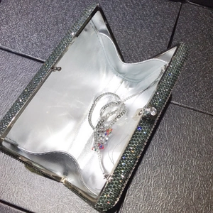 Macro shot of silver crystal evening clutch bag with sparkling diamonds and metal chain