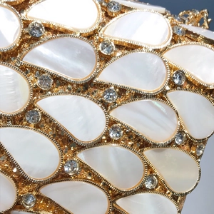 Detailed view of water-drop shell inlay and crystals on the golden evening clutch bag