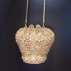 Détail de la pochette couronne ornée de strass dorés et de motifs floraux élégants