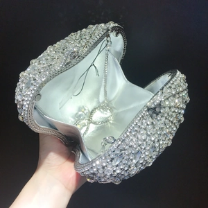 Détail d'un sac de soirée en forme de coquillage argenté avec strass et chaîne en métal
