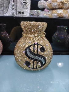 Macro view of crystal encrusted money bag clutch with dollar sign and gold chain