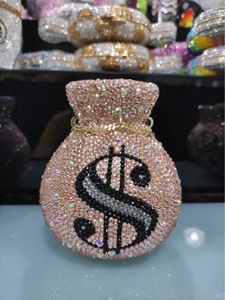 Macro shot of pink rhinestone evening bag with dollar sign and gold chain strap