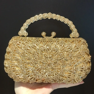 Luxurious gold evening clutch bag with sparkling rhinestones and ornate metal handle