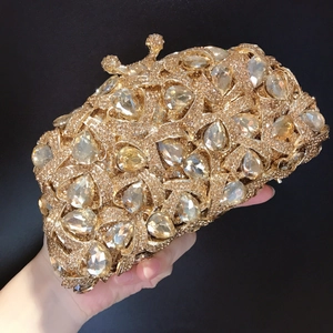 Detailaufnahme der goldenen Clutch mit Tropfenkristallen und Kronen-Diamantverschluss