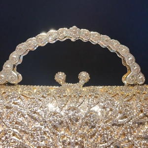 Luxury gold evening clutch bag with shimmering crystals and ornate metal handle