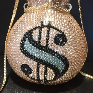 Spherical crystal dinner bag with gold chain strap and black dollar sign rhinestone pattern