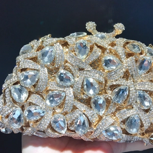 Detailaufnahme der goldenen Abendtasche mit großen Tropfenkristallen und funkelndem Diamantbesatz