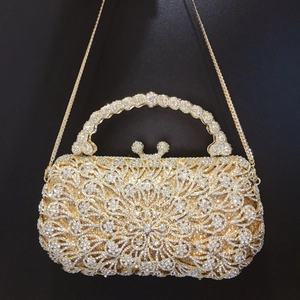Luxurious gold crystal evening bag with hollow pattern and rhinestone round handle