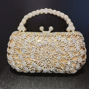 Macro detail of gold-tone floral hollow evening bag with sparkling rhinestones and metal handle