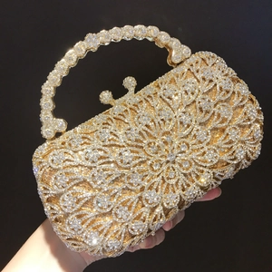 Close-up of golden evening clutch with floral hollow patterns and white rhinestones