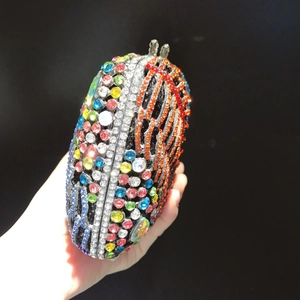 Handgehaltene ovale Abendtasche mit bunten Strasssteinen und Metallverschluss