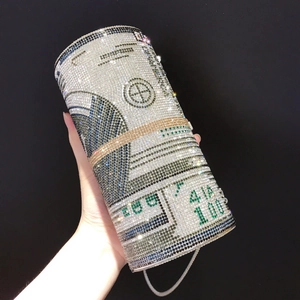 Close-up of a rhinestone cylinder evening bag with sparkling $100 dollar bill pattern