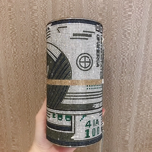 Detailed close-up of a cylinder evening bag with dollar bill pattern and rhinestones