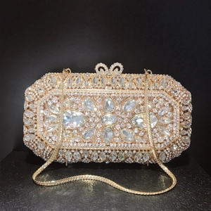 Close-up of champagne gold evening clutch with rhinestones and floral gem clusters