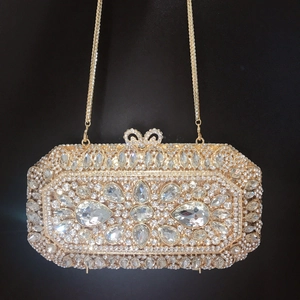 Close-up of luxury champagne gold evening clutch with rhinestones and floral crystal pattern