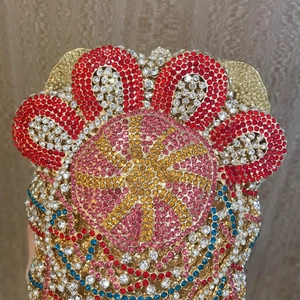 Close-up of luxury clutch with colorful rhinestones and floral metal frame design