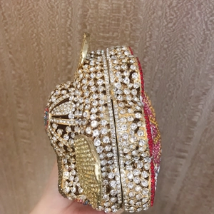 Detail of luxury evening clutch handbag featuring sparkling crystals and gold metal frame