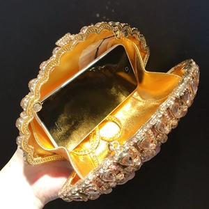 Interior view showing the storage capacity of a crystal-encrusted gold shell evening bag