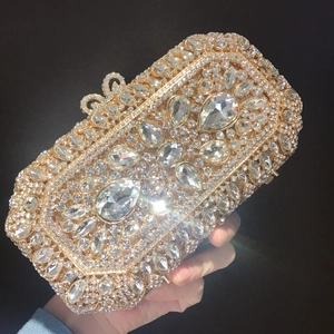 Close-up of luxury champagne gold evening bag with rhinestones and bow metal clasp
