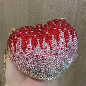 Detail of pink heart-shaped evening bag with gradient rhinestones and gold chain strap