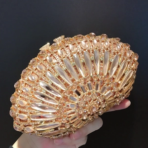 Macro shot of elegant champagne gold clutch with crystal bow clasp and sparkling gemstones