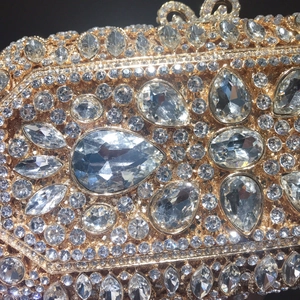 Macro detail of luxury champagne gold clutch with hand-set crystal rhinestones