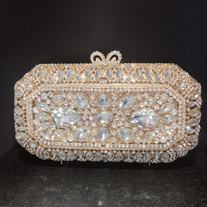 Exquisite close-up of champagne gold evening bag with luxury rhinestone floral patterns