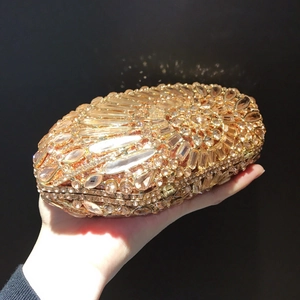 Detailed view of hand-held shell evening clutch with luxury rhinestones and gold base