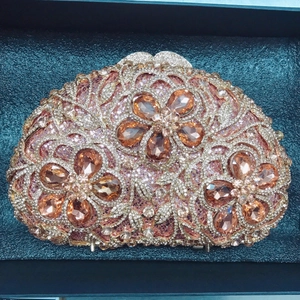Luxurious semicircular evening clutch with pink crystals and champagne floral details