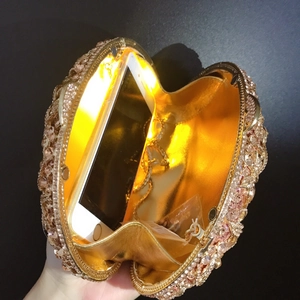 Detail of luxury rhinestone evening clutch showing interior light effect and phone capacity