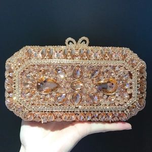 Detail of rose gold evening clutch featuring champagne crystals and bow clasp