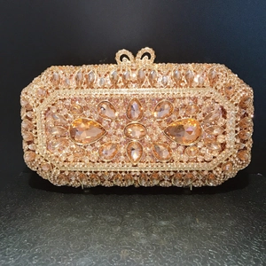 Detail of champagne gold evening clutch featuring rhinestone pavé and pear-shaped gems