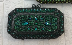 Detailed macro view of green crystal rhinestones and bow clasp on a luxury clutch bag